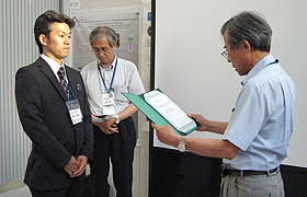 (left) Dr. Takashi Morinaga is awarded from Prof. Kohei Uosaki