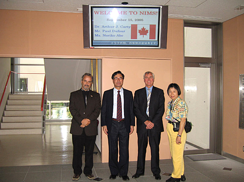 "Dr. Carty and his followers pose with Prof. Aono in front of a welcome board." Image