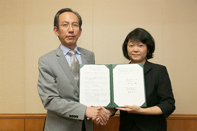 "NII Director General Kitsuregawa (left) and NIMS Executive Vice President Nagano shaking hands after signing the memorandum at NII on May 30" Image