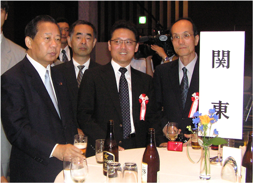 「写真: 受賞パーティーにて二階経済産業大臣を囲むSWING、オキサイドのメンバー」の画像