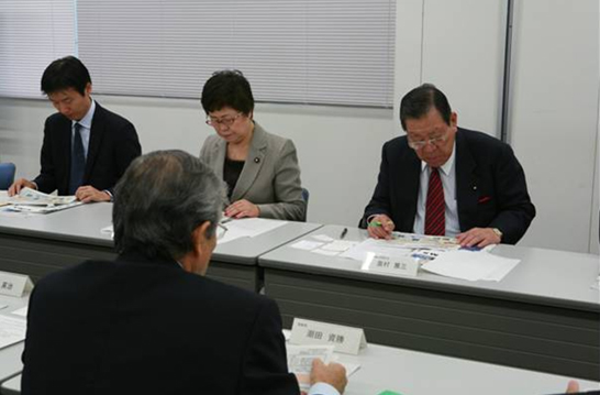 「写真1 : NIMSの概要説明をお聞きになる奥村副大臣(右)と神本政務官(中央)」の画像