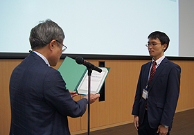 授与される野村　晃敬氏（右）と魚崎拠点長（左）