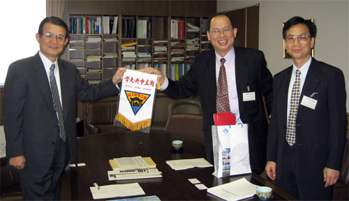 "Prof. Lee, center, presents a NCU memorabilia to Prof. Kishi." Image