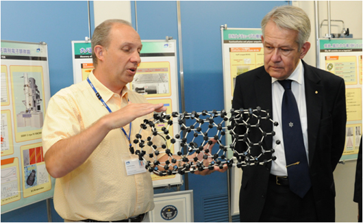"Prof. Lindqvist listening to an explanation of nanotubes by Dr. Dmitri Golberg, a MANA Principal Investigator" Image