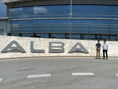 ALBA Synchrotron屋外ロゴ看板傍にて、 Ponrouch博士と万代GLが並んで立つ様子