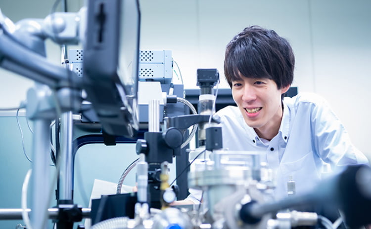 若手研究者が実験装置を操作するイメージ