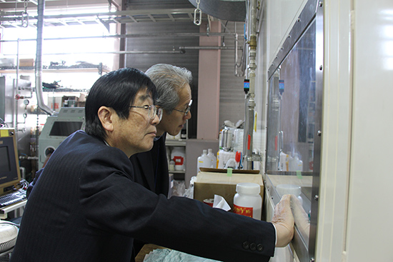 「高温材料のコーティング現場を視察される冨岡政務官」の画像