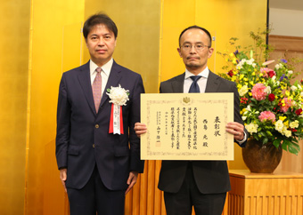 「表彰式の様子。 (写真左) 産業技術環境局 山下隆一 局長、 (写真右) NIMS 西島元 主幹研究員」の画像