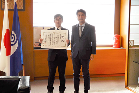 「授賞式での記念撮影の様子。 (左) 樋口 昌芳 グループリーダー、 (右) 大井川茨城県知事」の画像