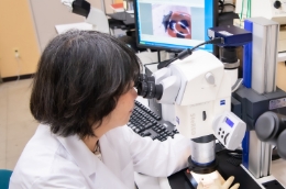 細田研究員と顕微鏡の写真